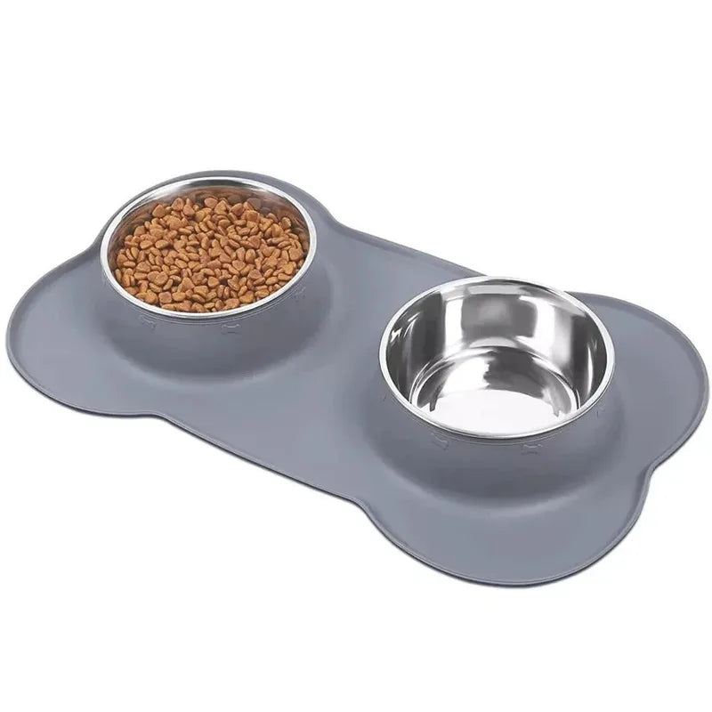 Grey bone-shaped silicone mat with two steel bowls, one full of kibble