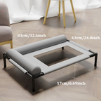 Grey raised dog bed on a wooden floor beside a chair, with its length, width and height marked