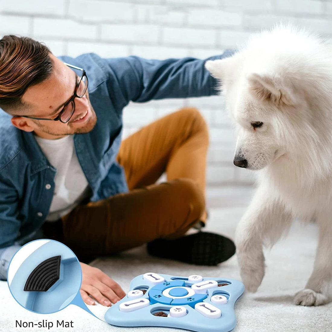 Light blue treat puzzle on a living room floor with a white fluffy dog, a man and a close-up of the base